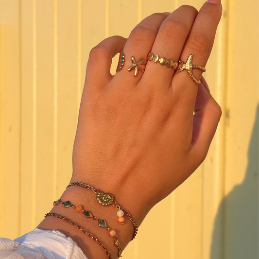 aanfoto zomerse armbanden oranje en ringen schelpen