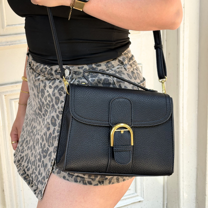 white handbag with gold clasp and shoulder strap