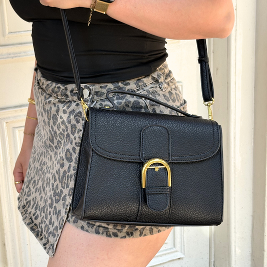 white handbag with gold clasp and shoulder strap