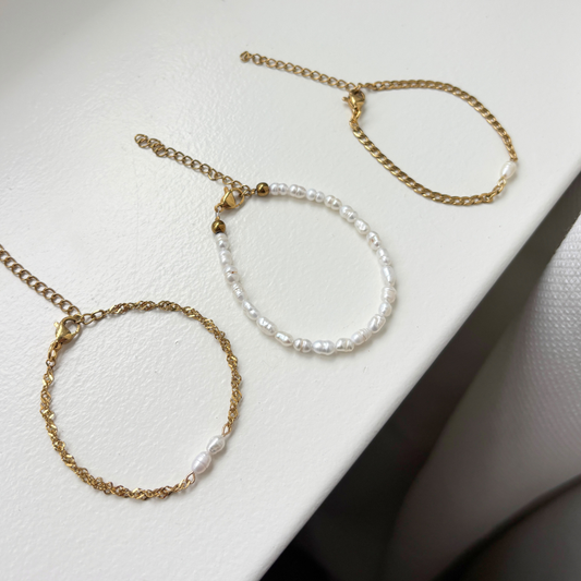 sfeer foto van 3 zoetwaterparel armbandjes met goud stainless steel