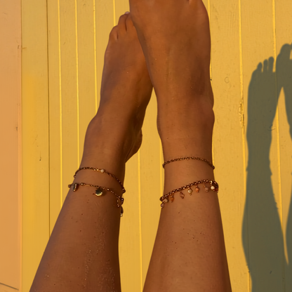 sfeerfoto van enkelbandjes zomerse kleuren strandhokje golden hour