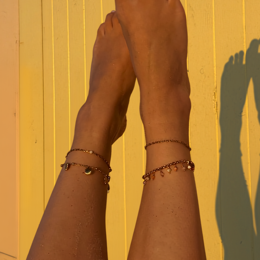 sfeerfoto van enkelbandjes zomerse kleuren strandhokje golden hour